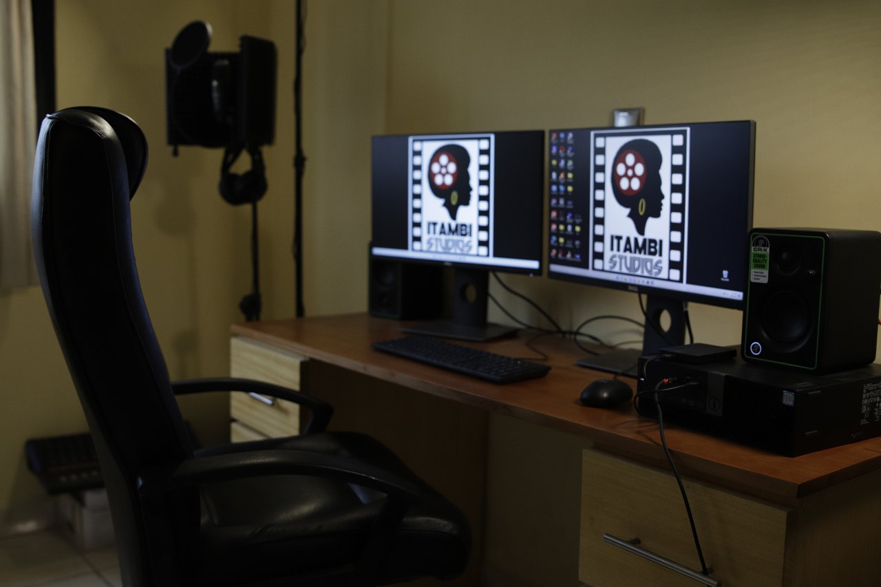 A post-production workstation with monitors and a recording microphone.