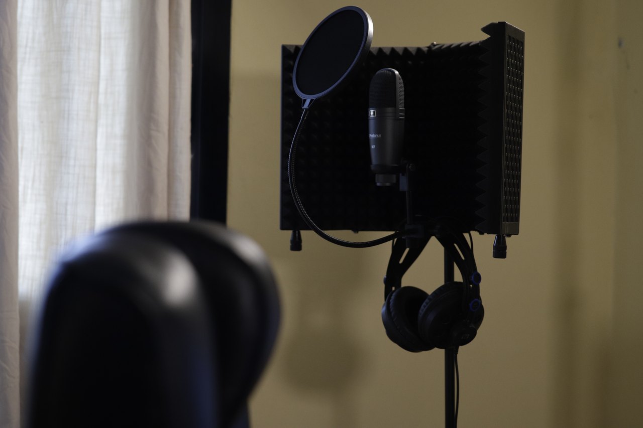 Headphones and a studio microphone at a sound recording station.