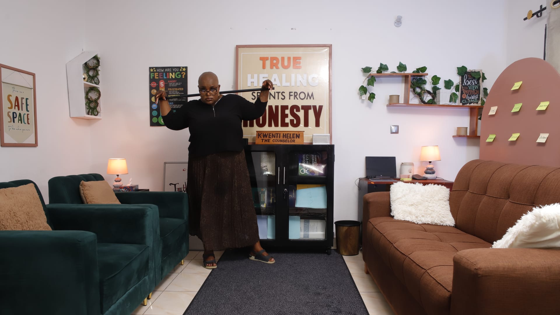 A counselling room set with armchairs, sofas and a wall poster reading True Healing Sprints From Honesty.