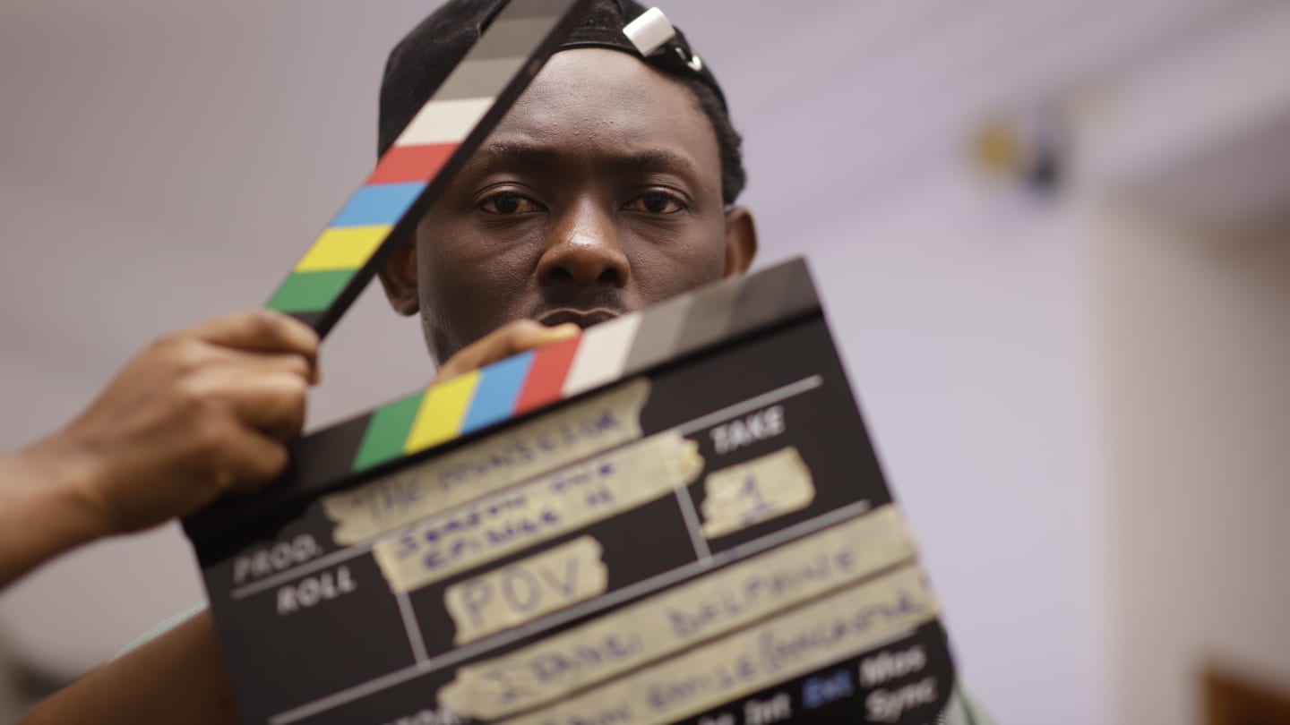 Crew member holding a production clapperboard during filming.