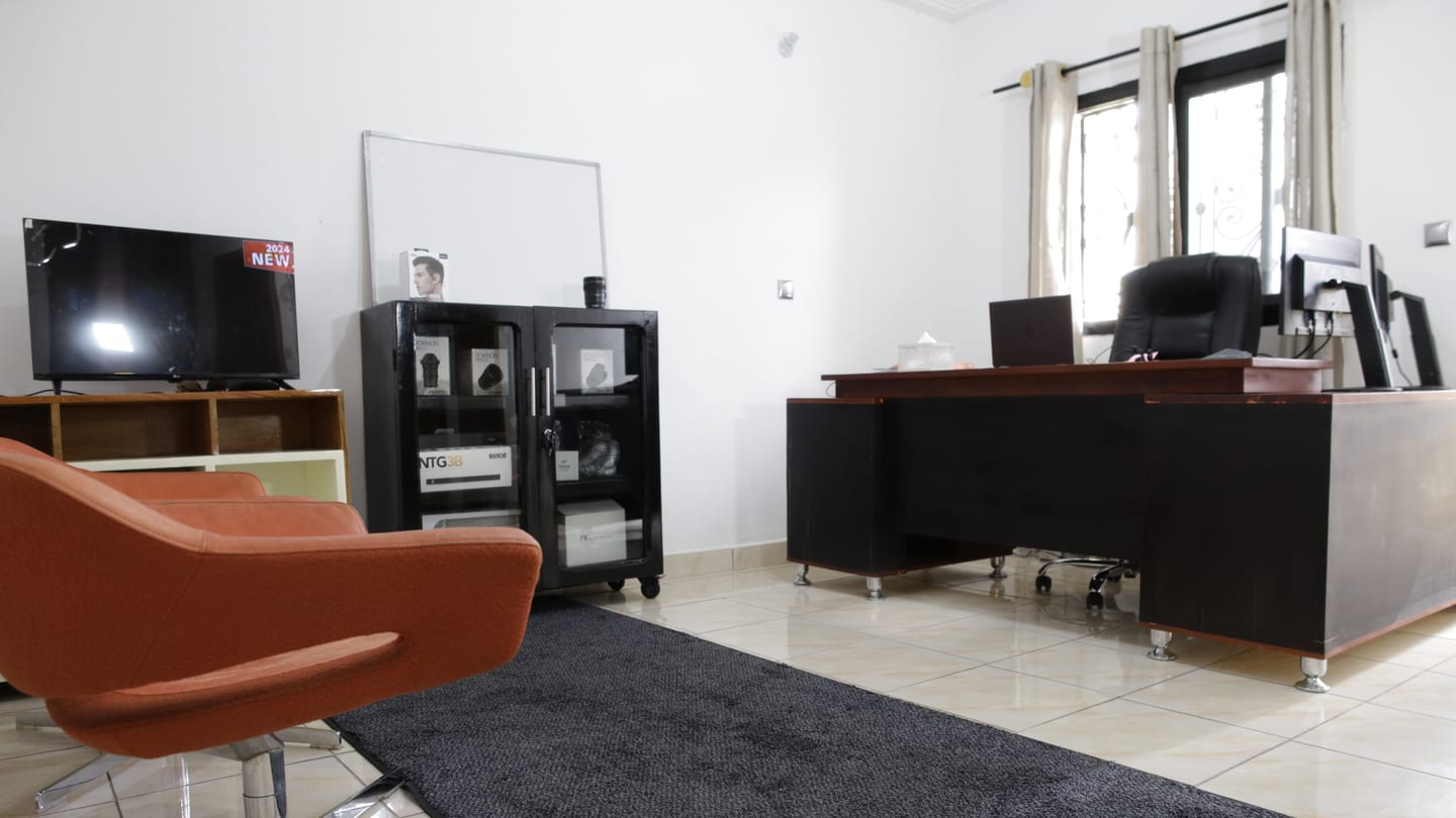 Itambi Studios office interior with a desk, lounge seating, and a display cabinet.