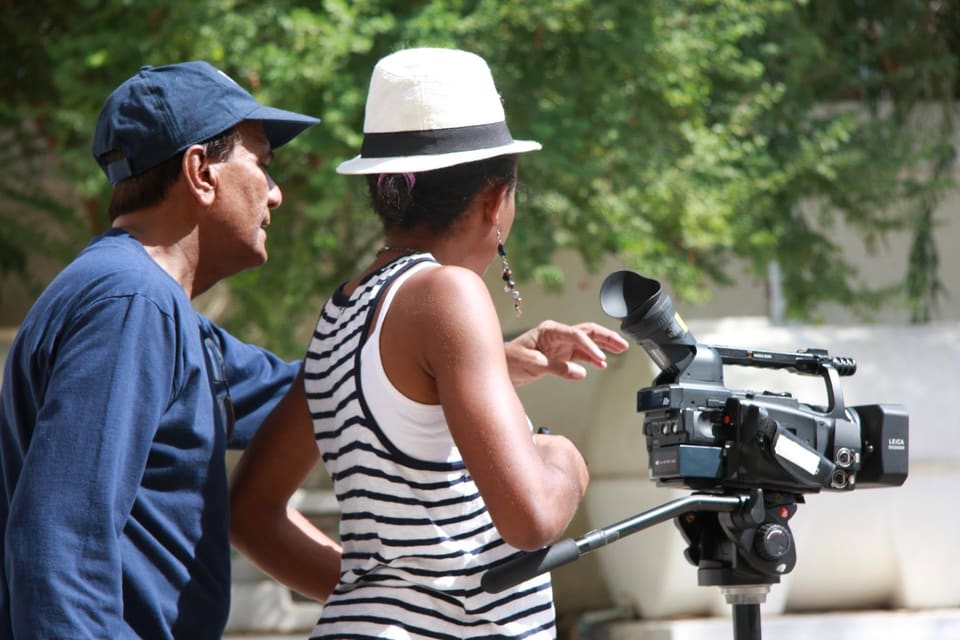 A camera operator and collaborator preparing a shot outdoors.