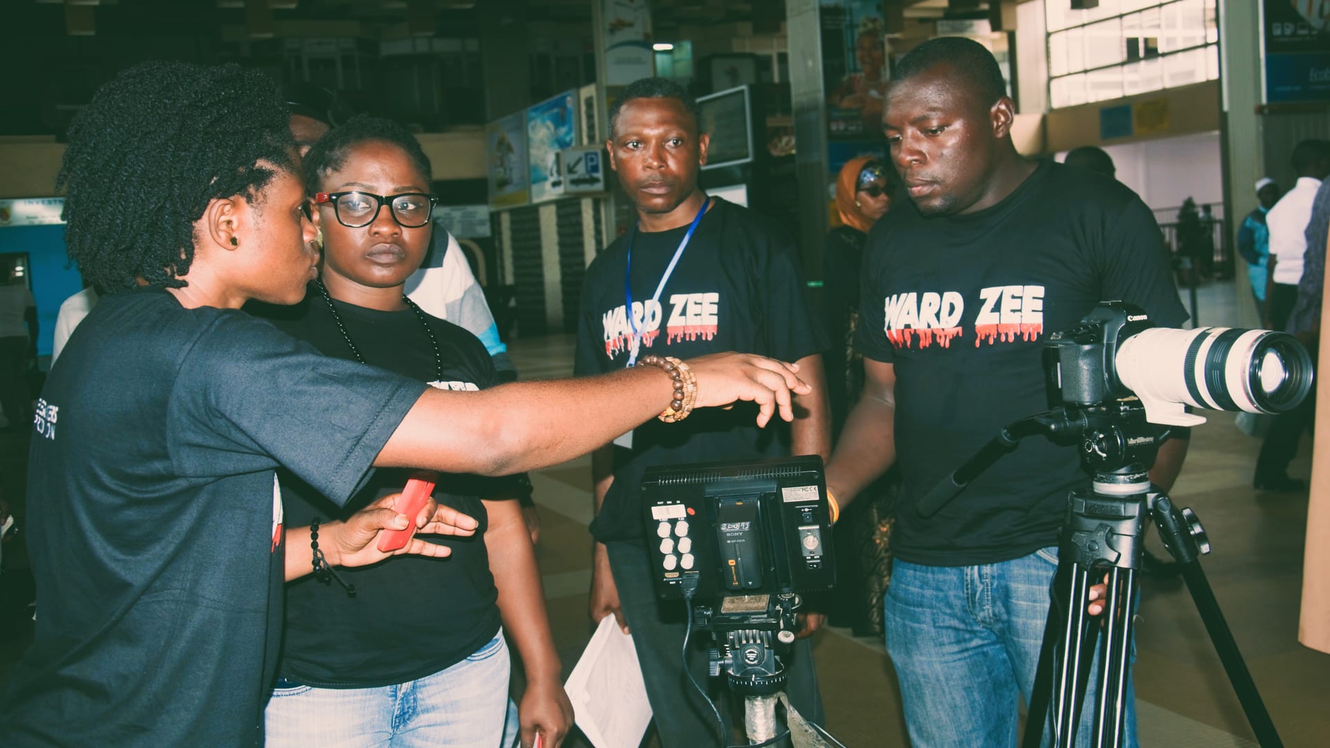 Itambi Studios crew setting up a camera on a tripod while filming on location.